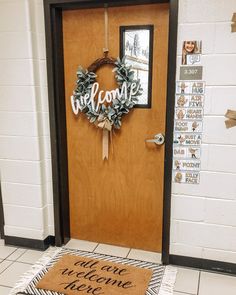 a welcome mat is on the floor in front of a door that has a wreath