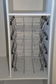 a white cabinet with wire baskets in it