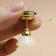 a tiny gold lighter is being held by someone's hand with a green clover on it