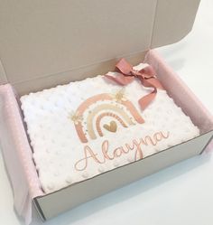 an open box with a baby blanket in it that says aloyna on the front