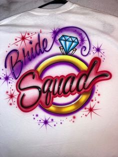 the bride squad t - shirt is white with purple, yellow and red lettering on it