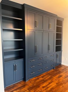 an empty room with many cabinets and drawers on the wall, in front of a hardwood floor