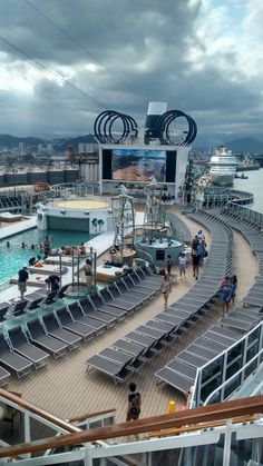 people are walking around on the deck of a cruise ship as it floats through the water