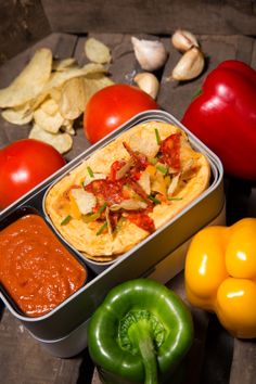 an assortment of vegetables including peppers, tomatoes and tortilla bread in a tin