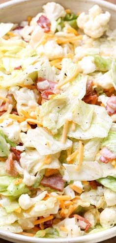 a salad with lettuce, bacon and cheese in a bowl