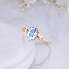 an engagement ring with a blue topazte surrounded by white flowers