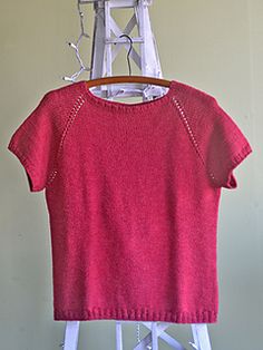 a pink sweater hanging on a clothes rack