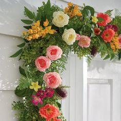 a wreath made out of flowers hanging from the side of a door