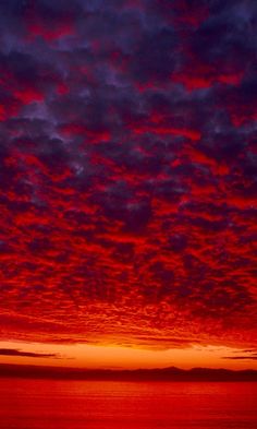 the sky is red and purple with clouds