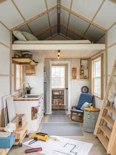 the interior of a tiny home with wood floors and walls, including stairs leading up to an open floor plan