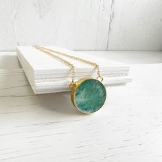 With its vibrant blue-green hue and classic gold chain, this Amazonite necklace will elevate any outfit. GEMSTONE: AmazoniteSIZE: 0.75" longCHAIN: 18" long 14k gold filledCLOSURE: Lobster clasp Luxury Blue Amazonite Jewelry, Stone Circle, Amazonite Necklace, Amazonite Stone, Circle Pendant Necklace, Classic Gold, Vibrant Blue, Circle Pendant, Long Chain