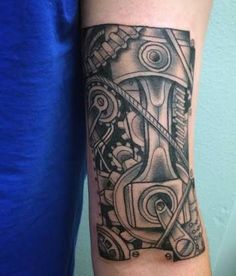 a black and white tattoo on the arm of a man with a car engine in it