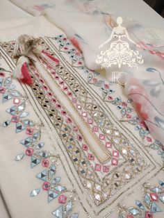 an embroidered dress with beading and sequins is displayed on a white table