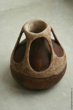 a brown vase sitting on top of a white floor