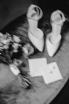 the bride's shoes and bouquet of flowers are sitting on the table next to each other