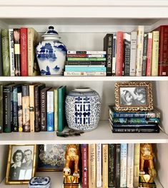 a bookshelf filled with lots of books and vases on top of it