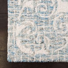 a blue and white rug on top of a wooden floor