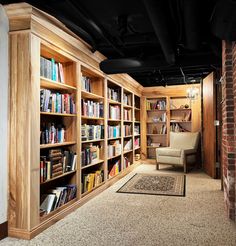 an empty library with lots of books on the shelves and a chair in front of it