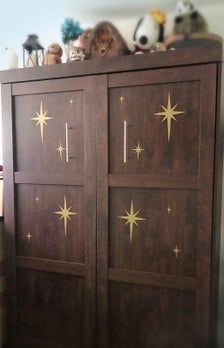 a wooden cabinet with gold stars painted on it