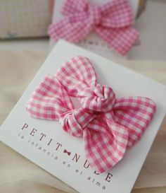 a pink and white checkered bow on a card