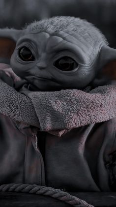 a baby yoda is wrapped in a blanket