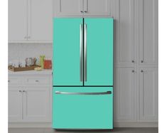 a green refrigerator freezer sitting in a kitchen next to white cabinets and cupboards