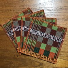 three woven coasters sitting on top of a wooden table