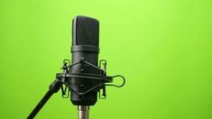 an old fashioned microphone on a stand against a green background