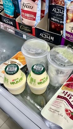 yogurt and other drinks are on display in a grocery store's refrigeration section