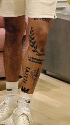 a man's legs with tattoos on them