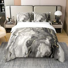 a bed with a white and black comforter on top of it