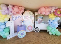 a table with balloons and donuts on it