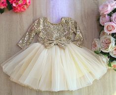 girl's Gold sequin Birthday party dress with sleeves, Flower girl dress, Gold sparkle tulle dress All dresses are handmade with the high quality. We make this dress from a soft sequin and tulle, with the cotton lining inside. Before order please, check your child's measurements on the size chart. Make sure the dimensions are correct. If there is no measurement in the table, you can send us your kid's measurements as a message. All your orders comes by fast delivery to a warehouse in Blaine, MN at first. Then every order comes by USPS to thier address. It's the fastiest way by standart shipping and it takes 10-12 days after shipping. But if you need to get the dress in 6-7 days, you can upgrate your shipping. We'll send it ASAP.  Hava a happy shopping! Fitted Tulle Princess Dress For Party, Festive Sequined Tulle Dress, Festive Tulle Dress With Sequins, Spring Party Tutu Dress With Long Sleeves, Spring Party Long Sleeve Tutu Dress, Festive Sequin Glitter Tulle Dress, Holiday Party Tulle Tutu Dress, Holiday Party Tutu Dress Made Of Tulle, Spring Party Princess Dress With Long Sleeves