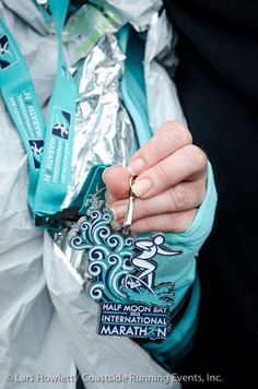 a person holding a medal in their hand and wearing a lanyard around her neck