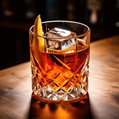 a glass filled with ice and an orange slice sitting on top of a wooden table