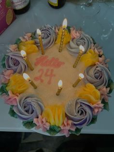 a birthday cake decorated with flowers and candles