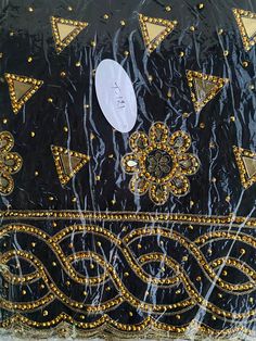 Tired of the regular black velvet and Ankara/Pagne Africain Tohgu/Atoghu fabrics?    Well, step into our world of innovation and stand out on your special day with this newly crafted  Tohgu/Atoghu inspired beaded George Lace fabric. This beautiful beaded George Lace fabric is a luxurious and exquisite material that exudes elegance and sophistication. The intricate beading and delicate lace with a tough of Toghu spiral embroidery beading details create a stunning and eye-catching design that is s Embroidered Evening Saree For Eid, Embroidered Saree For Eid Evening, Embroidered Saree For Evening And Eid, Embroidered Evening Saree For Festivals, Festive Embellished Black Traditional Wear, Black Traditional Wear With Mirror Work For Evening, Embellished Black Bollywood Dupatta, Black Embellished Bollywood Dupatta, Black Embellished Traditional Wear For Diwali