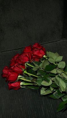 a bunch of red roses sitting on top of a black couch next to each other