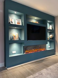 an entertainment center with built - in shelves and a fire place