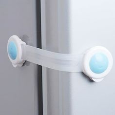 a close up of a door handle on a refrigerator with blue knobs and white handles