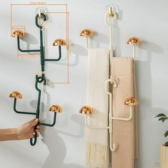 a wall mounted towel rack with four hooks and two towels hanging on it's sides