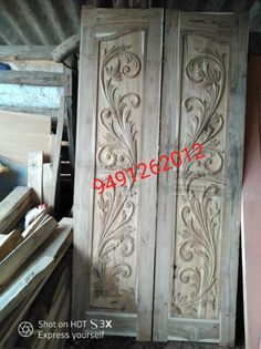 an old wooden armoire with carvings on the front and back doors, in a warehouse