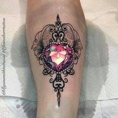 a woman's leg with a tattoo on it and a pink diamond in the center