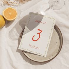 a table setting with oranges, wine glasses and place cards for an elegant wedding