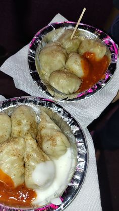 two metal pans filled with food on top of a table