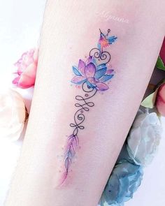 a woman's leg with a watercolor tattoo design on the left side of her thigh