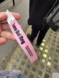 a person holding up a pink sticker with the word think never die on it