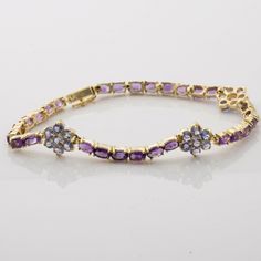 "14K Yellow Gold 5ct + Amethyst and Tanzanite Rosette Bracelet, 7 round tanzanite in a 10mm rosette with the bracelet, formed of 3x5mm fine amethyst ovals, 7/32\" across, 7.5\" length, locking box clasp, Circa 1990, 10 grams Stock # BB245R02 This listing contains photographs of the actual item you will receive. Our items are in excellent condition with little or no signs of wear and many are one of a kind pre-owned estate finds. Please look closely at the pictures in this listing as they are par Purple Jewelry With Jubilee Bracelet For Anniversary, Formal Purple Tanzanite Jewelry, Lavender Tanzanite Jewelry For Anniversary, Formal Lavender Tanzanite Jewelry, Formal Purple Fine Jewelry Bracelet, Anniversary Tanzanite Jewelry In Lavender, Elegant Lavender Hallmarked Jewelry, Round Tanzanite Bracelets For Formal Occasions, Lavender Tanzanite Jewelry