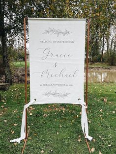 a welcome sign in the grass for a wedding