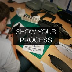 a man sitting at a table with scissors and other items on it that says show your process